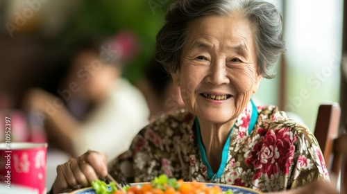 portrait of a retired happy elderly woman of asian chinese appearance celebrates a holiday in a restaurant, eats. concept: elderly health, old age, nutrition photo