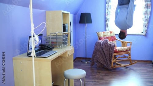 Man in jeans jumps on ceiling upside down at inverted house