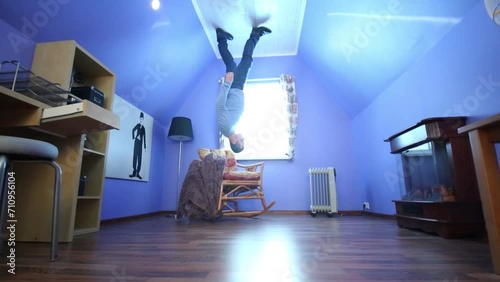 Man on ceiling upside down in blue room in inverted house