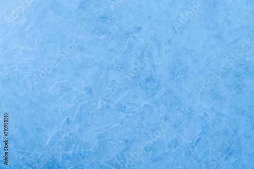 Icy winter background cracked grunge texture. Natural scratched ice on a skating rink as a texture or background for a winter composition, large long painting