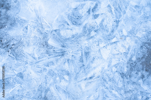 Icy winter background cracked grunge texture. Natural scratched ice on a skating rink as a texture or background for a winter composition, large long painting