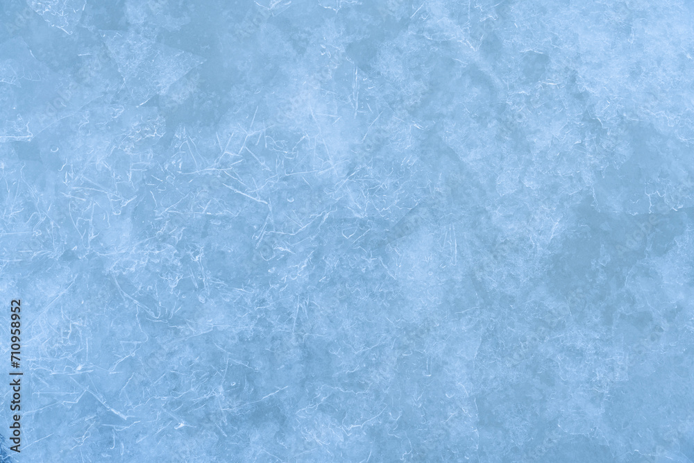 Icy winter background cracked grunge texture. Natural scratched ice on a skating rink as a texture or background for a winter composition, large long painting Icy winter background cracked grunge texture. Natural scratched ice on a skating rink as a texture or background for a winter composition, large long painting