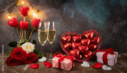 Valentine Ambiance with Roses and Heart Balloons, two glasses of champagne, gift basket; happy valentines day celebration night flat lay top view