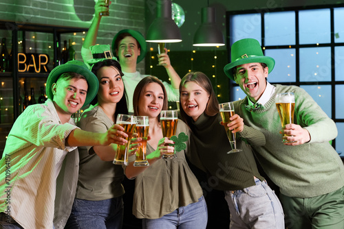 Group of young people with beer celebrating St. Patrick's Day in pub
