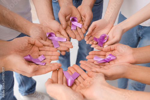 People with lavender awareness ribbons on light background, closeup. World Cancer Day #710970177