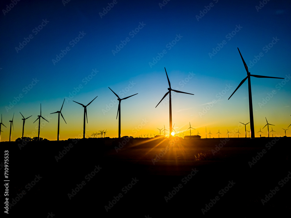 An image of windturbine generator in the field at sunset An image of windturbine generator in the field at sunset
