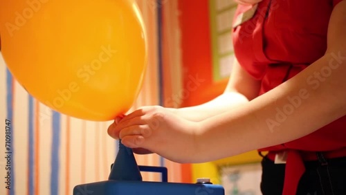 Hands of woman to inflate balloons with helium using device