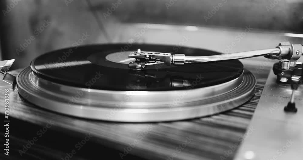 80s turntable, a vinyl rotates on the platter, vintage hi fi components,  black and white video,
