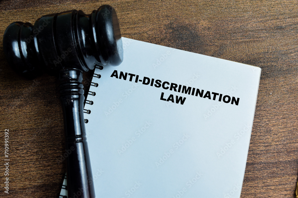 Concept of Anti-Discrimination Law write on book with gavel isolated on Wooden Table. Concept of Anti-Discrimination Law write on book with gavel isolated on Wooden Table.