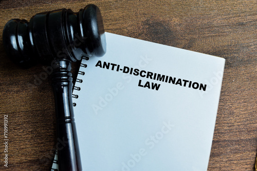Concept of Anti-Discrimination Law write on book with gavel isolated on Wooden Table.