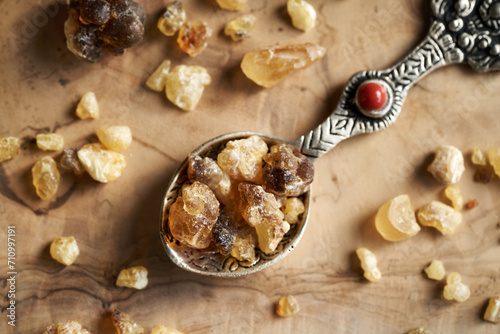 Frankincense resin crystals on a metal spoon on a table