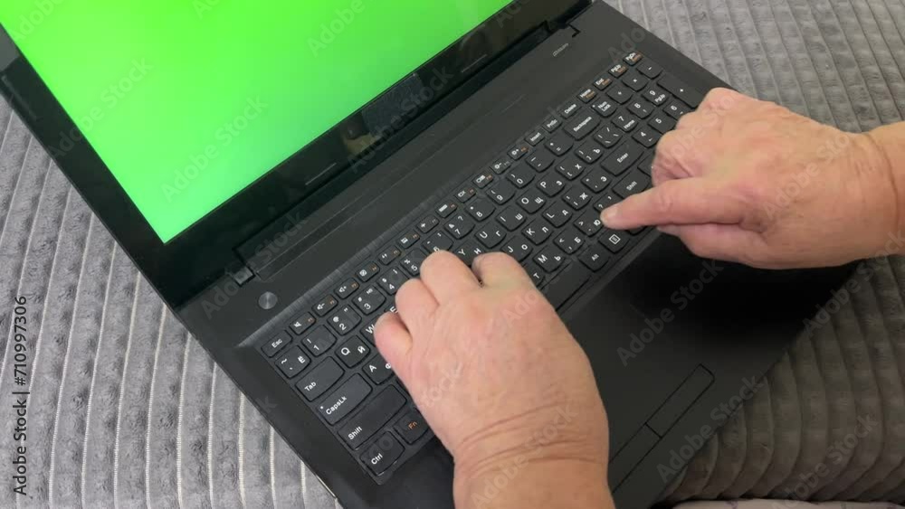 A pensioner learns to work on a laptop. Green screen video. Laptop with green screen chromatic keyboard and plump female hands. Mature female hands slowly type text on the keyboard. Grandmother. A pensioner learns to work on a laptop. Green screen video. Laptop with green screen chromatic keyboard and plump female hands. Mature female hands slowly type text on the keyboard. Grandmother.