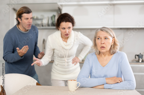 Adult children man and woman clashed over financial question with elderly woman mother. Family feuds, generational conflict, misunderstanding due to different views and opinions