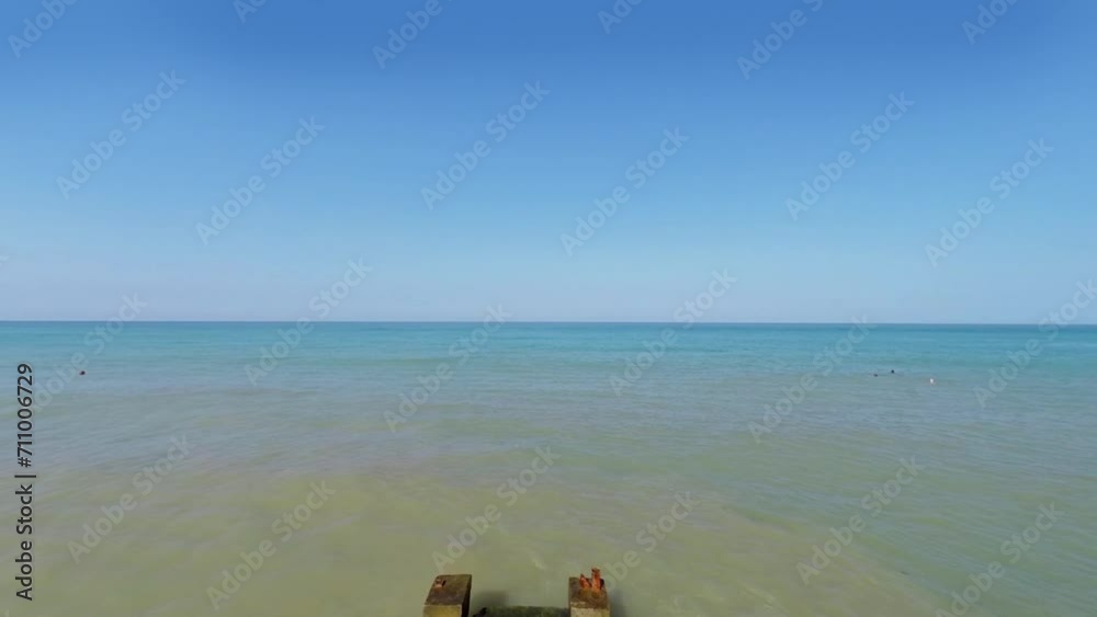 Retiree and his daughter stand on stone moorage in sea Retiree and his daughter stand on stone moorage in sea