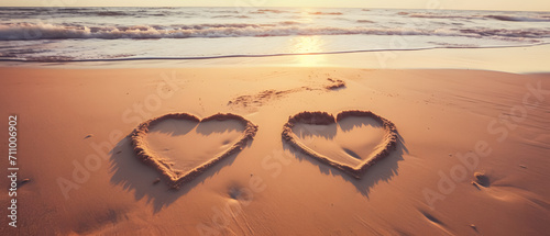 2 hearts drawn in the sand of a beautiful beach photo