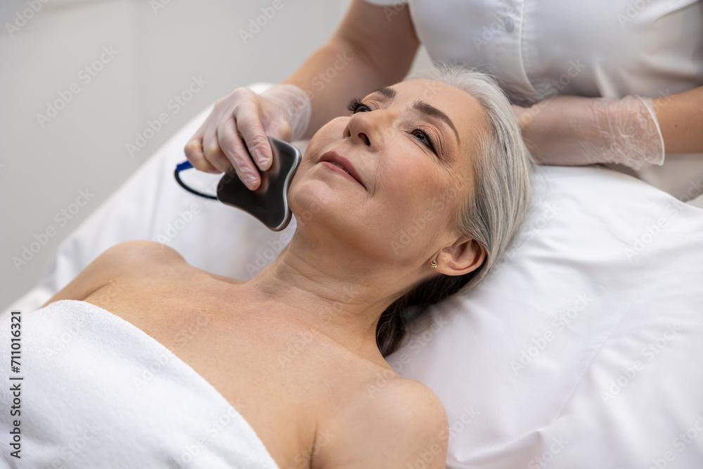 Naklejka premium Mature gray-haired woman having a mesotherapy treatment