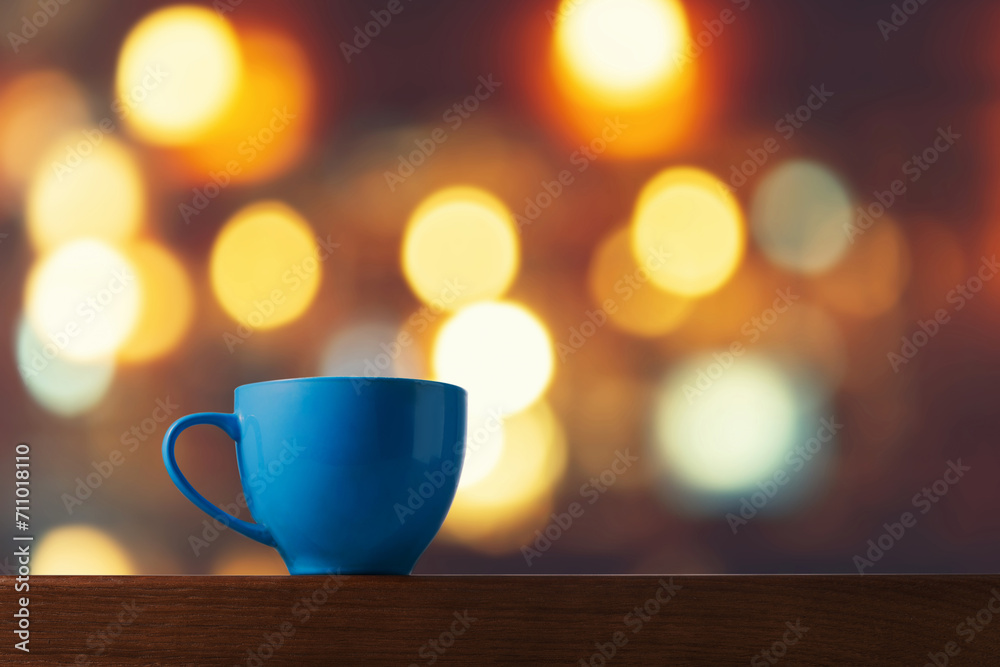 Blue Ceramic Cup on Wooden Table with Bokeh Background Lights Blue Ceramic Cup on Wooden Table with Bokeh Background Lights