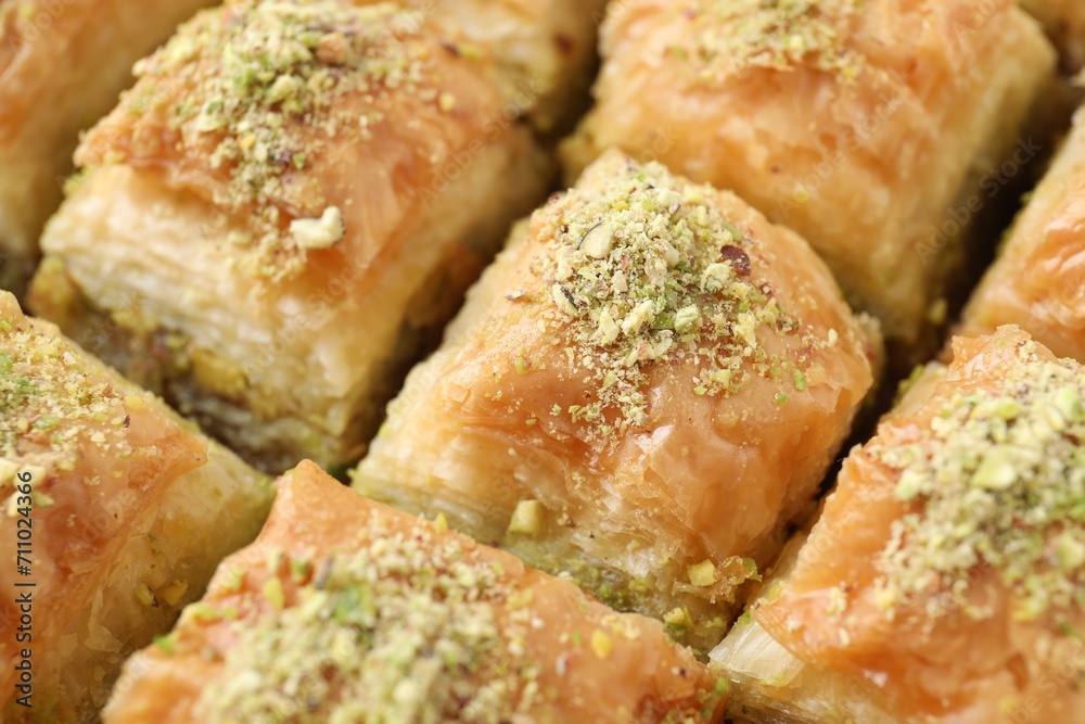 Delicious fresh baklava with chopped nuts as background, closeup. Eastern sweets