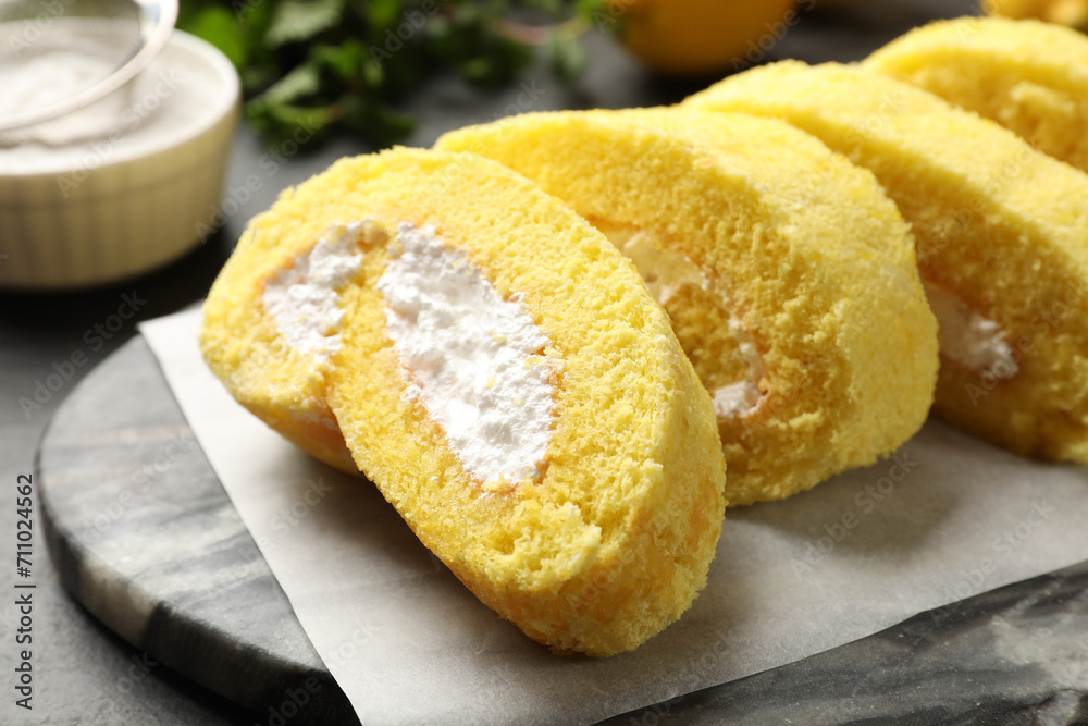 Delicious cake roll with cream filling on grey table, closeup Delicious cake roll with cream filling on grey table, closeup