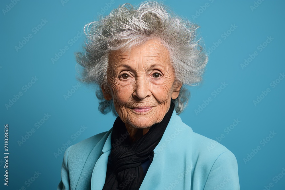 Portrait of a happy senior woman smiling at the camera on a blue background Portrait of a happy senior woman smiling at the camera on a blue background