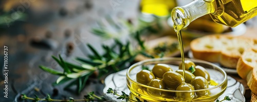 olden olive oil bottle pouring over green olives plate with thyme and aromatic herbs leaves  photo