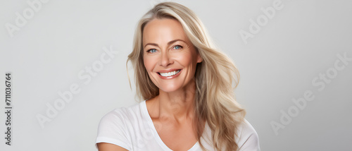 Beautiful middle-aged woman on a gray background. photo