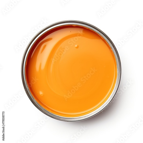 Open tin can of orange paint on a white background, top view. Open a round can of bright orange paint. Ideal paint texture, uniform warm color. Template for palette, sticker. photo