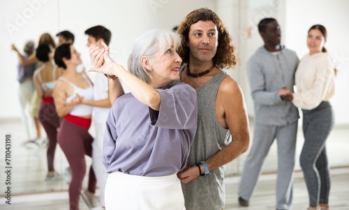 Adult couples of dancers  engaged in a dance studio  studying salsa in lesson