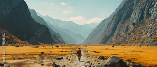 Man walking alone through a vast desert canyon photo