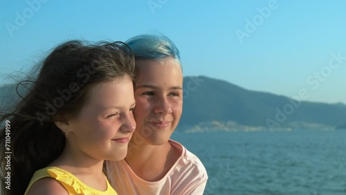 Portrait of sisters at sea. Happy little girl on the background of the sea landscape. photo