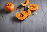 cut pumpkin slices on gray wooden table with copy space