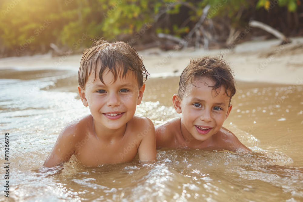 Two young boys are playing in the water and smiling Two young boys are playing in the water and smiling