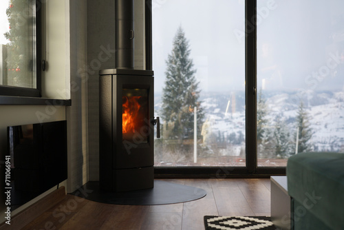 Modern fireplace and glass heater in a cozy house with mountain view photo