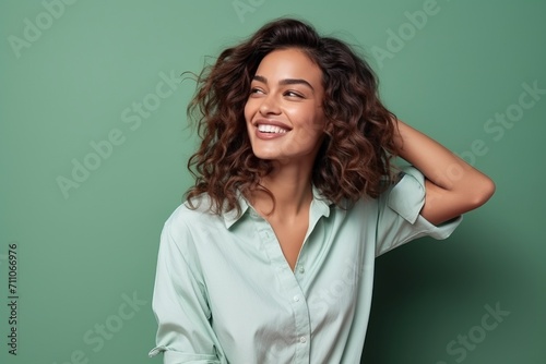 Portrait of a happy young woman with curly hair over green background