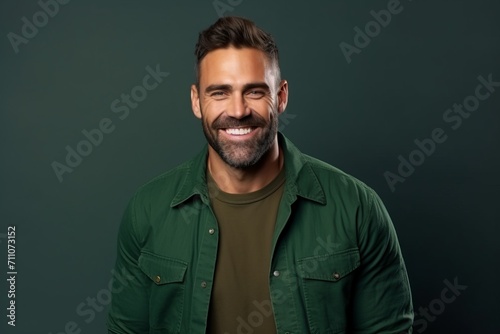 Portrait of a handsome man smiling at the camera over green background.