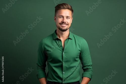 Handsome young man in a green shirt on a green background
