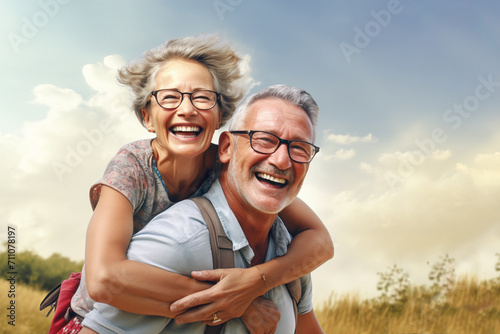 Happy senior couple, laughing away. Man carrying woman at his back. photo