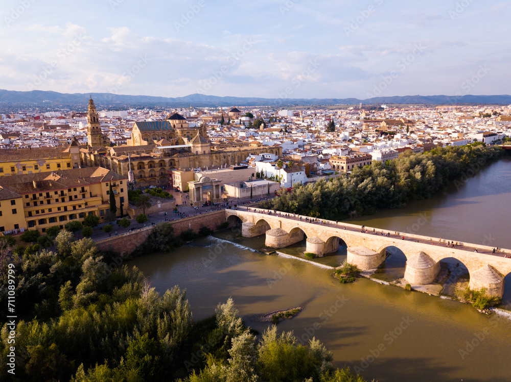 Fototapeta premium Aerial view of Historic centre of Cordoba with antique Roman Bridge over Guadalquivir river and medieval Mosque-Cathedral, Spain