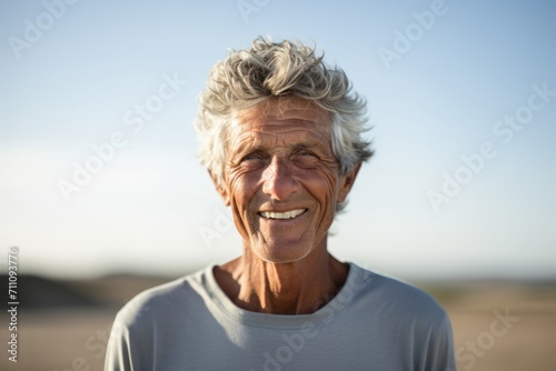 Portrait of senior man smiling at camera while standing in the countryside