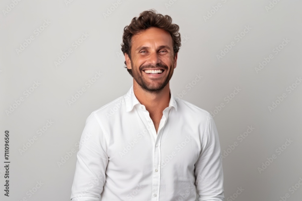Portrait of a handsome man smiling and looking at camera against grey background Portrait of a handsome man smiling and looking at camera against grey background