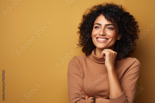 Portrait of smiling african american woman with curly hair on yellow background
