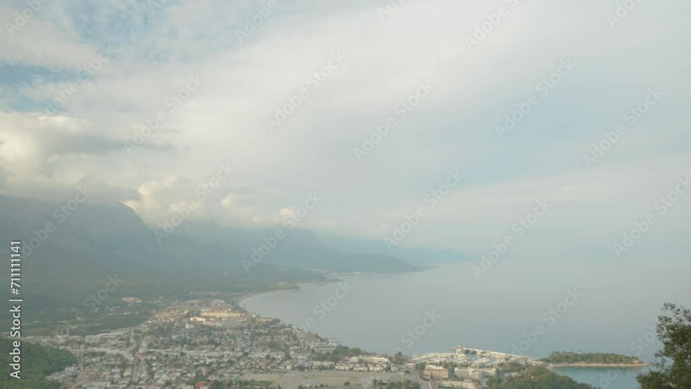 Journey of a Lone Young Woman, Feeling Freedom, She Stands at the Edge of the Abyss on a High Mountain with a View of the Sea and the City. Journey of a Lone Young Woman, Feeling Freedom, She Stands at the Edge of the Abyss on a High Mountain with a View of the Sea and the City.