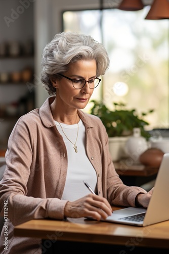 Contemplative senior woman working on laptop
