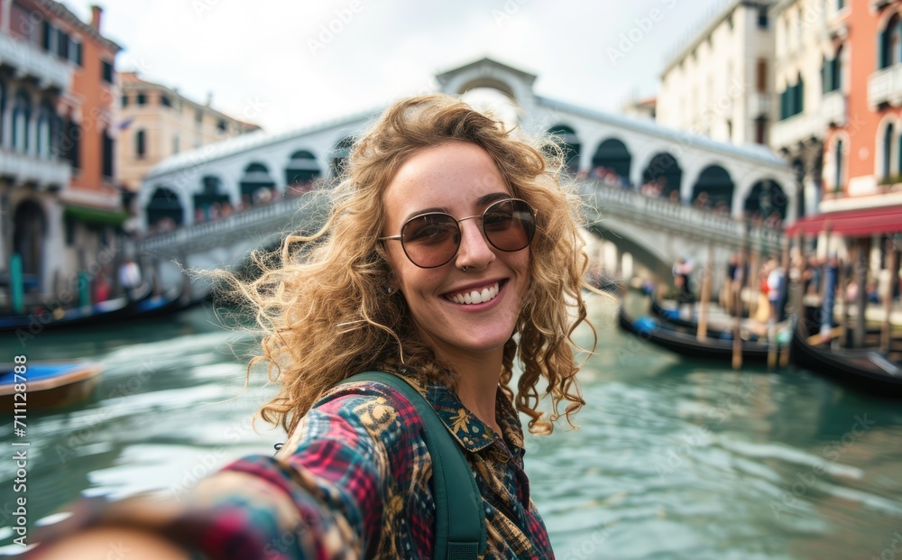 Venetian Adventure: A Young Native Woman, Backpack Adorned, Captures the Joy of Traveling with a Selfie near a Venice Bridge - A Genuine Smile Amidst Italian Heritage.

