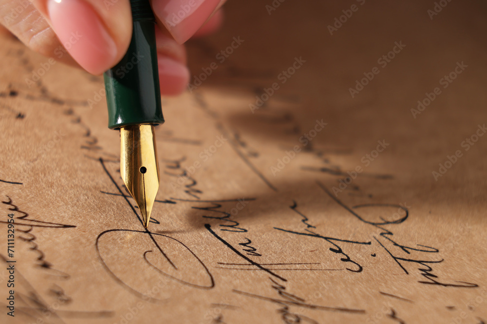 Fototapeta premium Woman writing letter with fountain pen, closeup