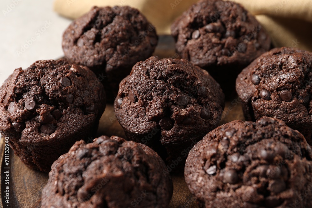 Board with delicious chocolate muffins on table, closeup Board with delicious chocolate muffins on table, closeup
