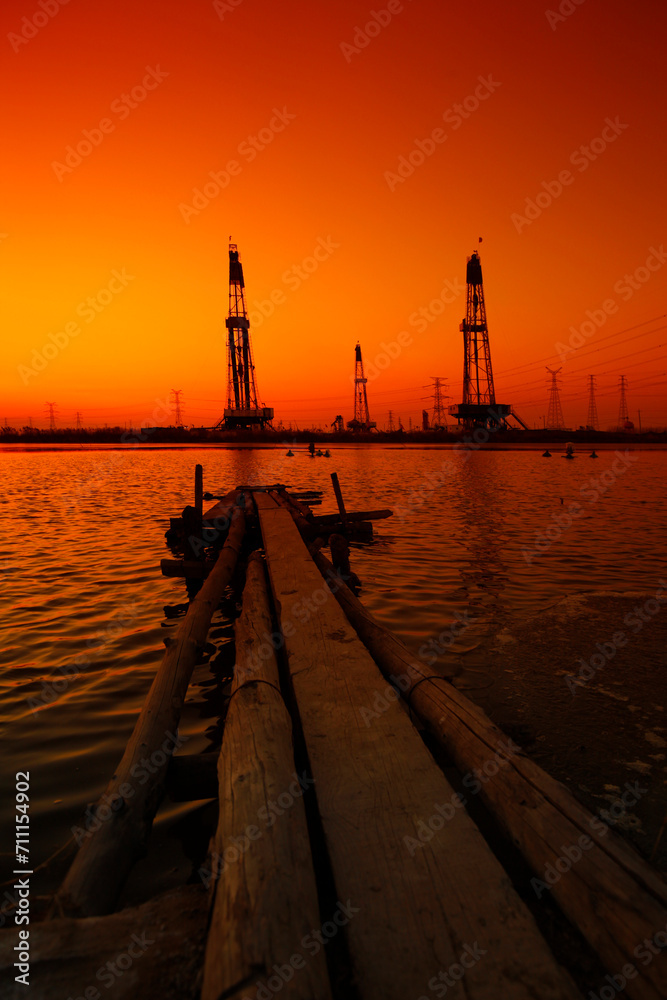 Sunset of oil drilling rig in the sea