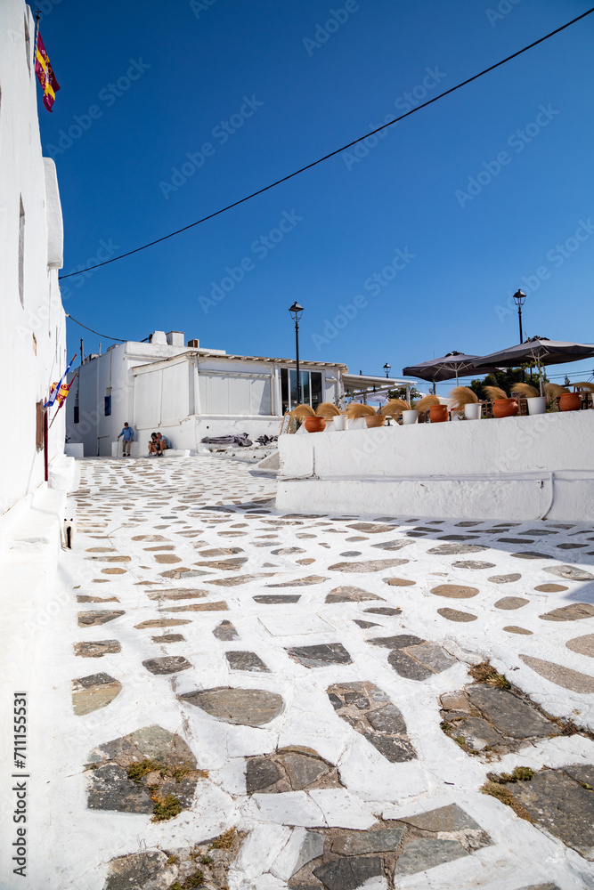 Streetview of Mykonos town with white street and blue door, Greece