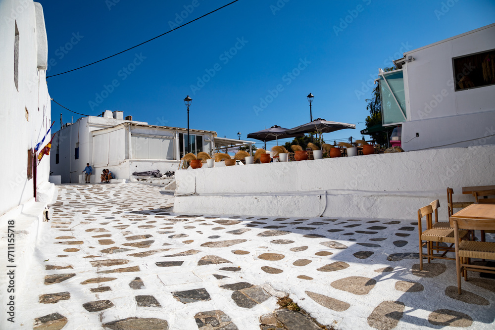 Streetview of Mykonos town with white street and blue door, Greece