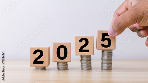 2025 text on wooden cube block with arranging stack of coin. planning, investment, savings , business strategy concept